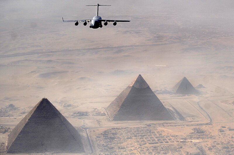 Airplane flying over pyramids