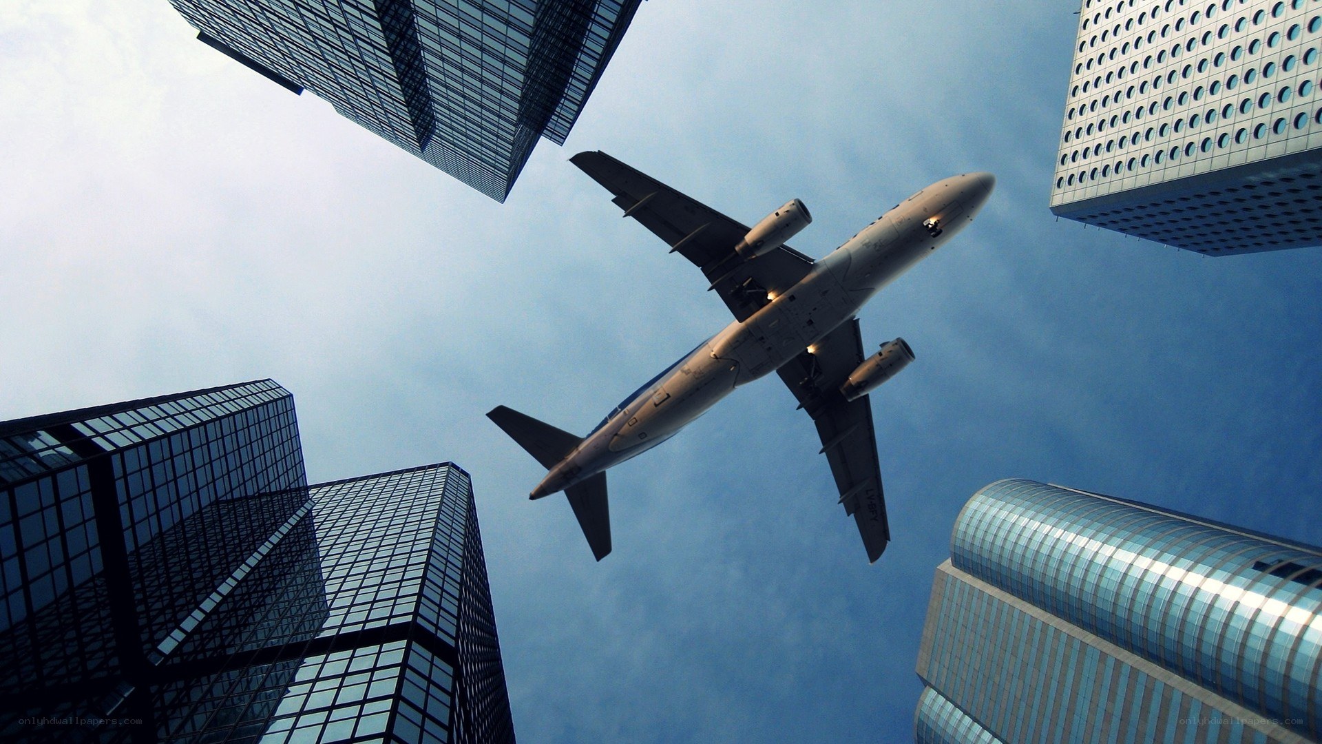 airplane flying over skyscrapers