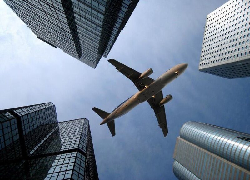 airplane flying over skyscrapers