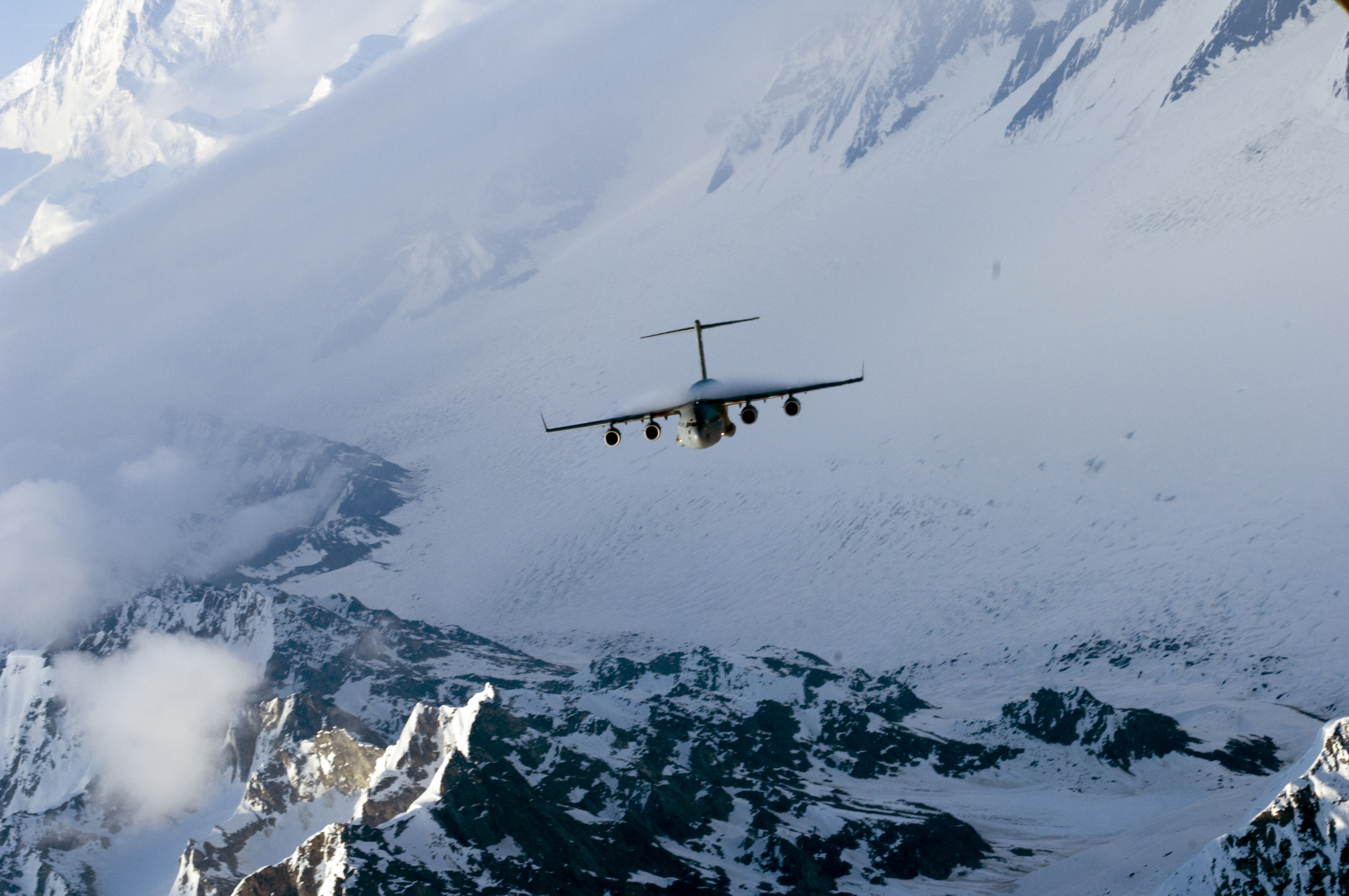 Airplane flying over snowy mountains