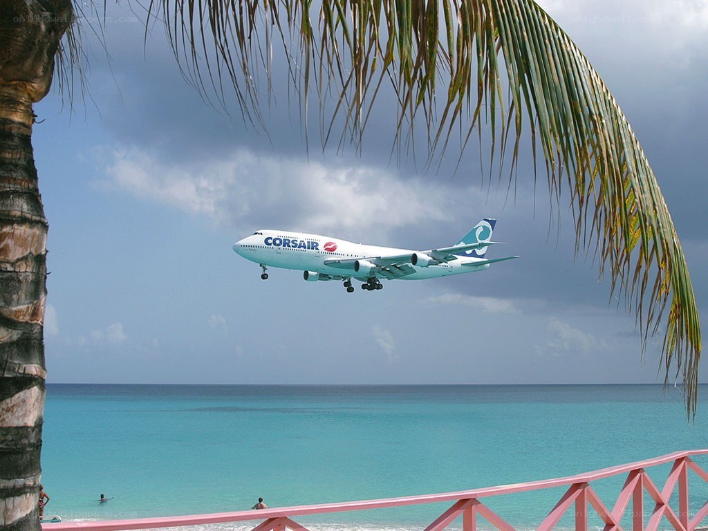 Airplane flying over tropical beach