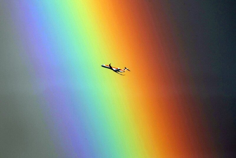Airplane flying through a rainbow