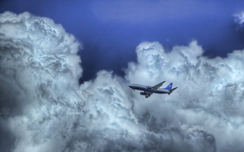 Airplane Flying Through Clouds — Blue, Dramatic, Photograph, Sky