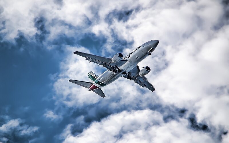 Airplane in Cloudy Sky — Dramatic