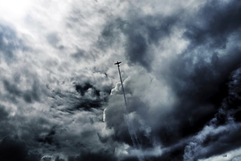 Airplane in Cloudy Sky — Gray, Dramatic, Photograph