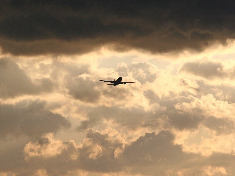 Airplane in Cloudy Sky — Gray, Dramatic, Sunset