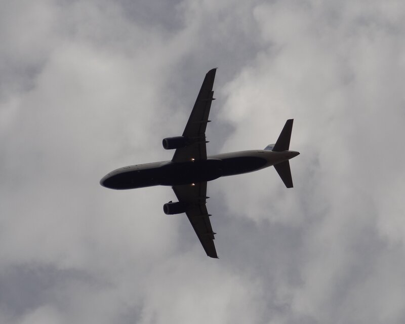 Airplane in Cloudy Sky — Gray, Overcast, Photograph