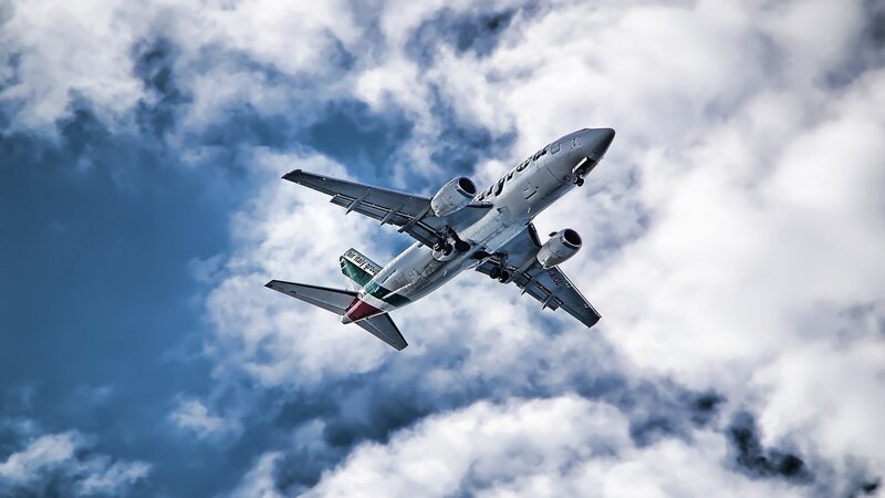 Airplane in Cloudy Sky — Photograph