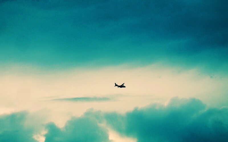 Airplane in Cloudy Sky — Teal