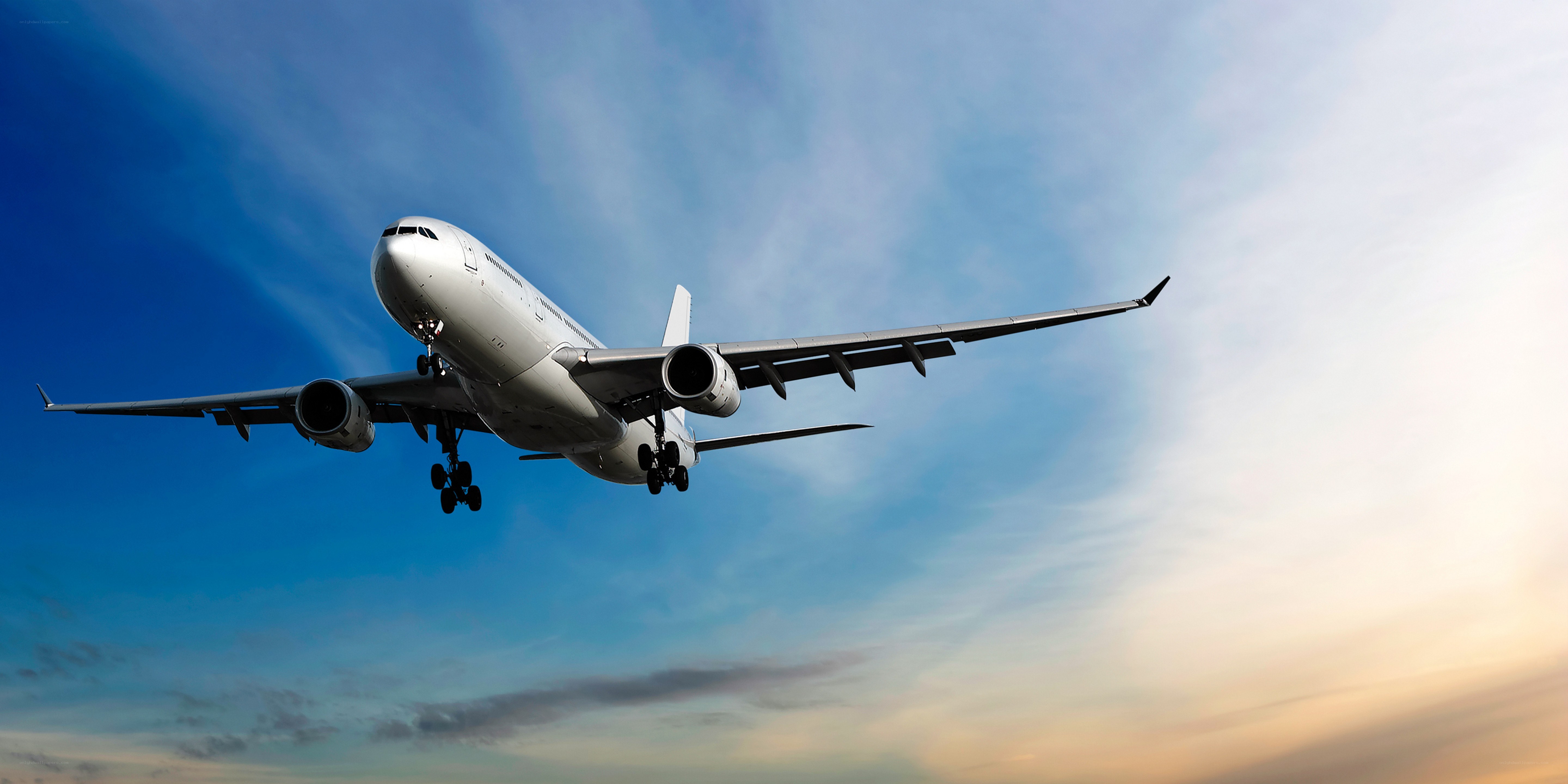 Airplane in flight at sunset