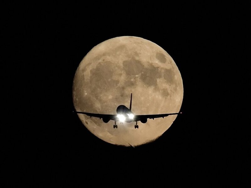 Airplane in front of the moon