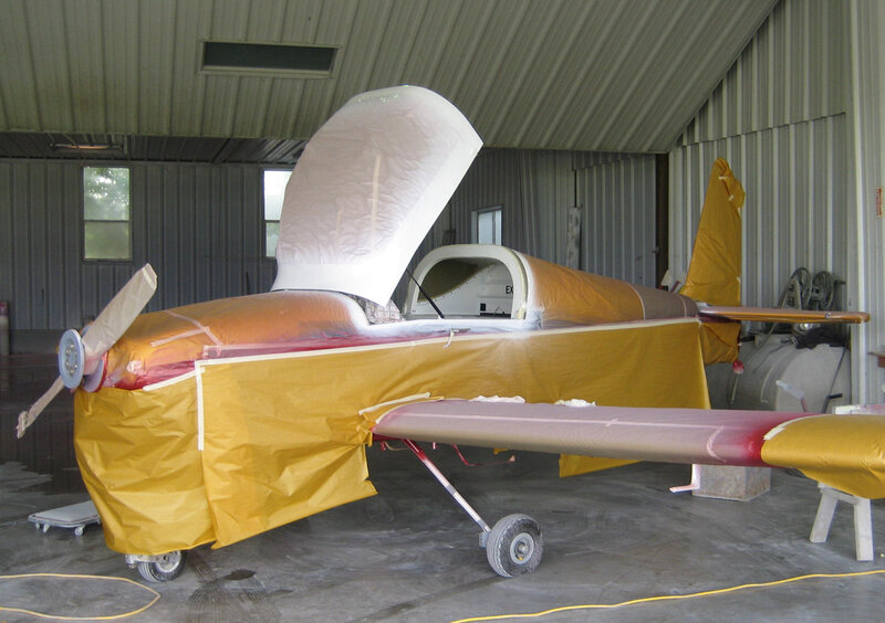 airplane in hangar being painted