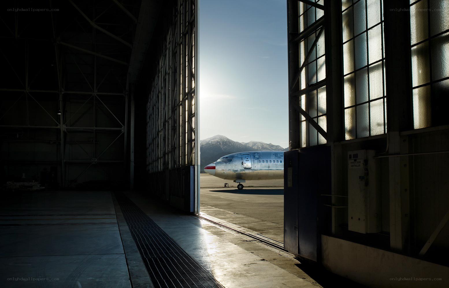 Airplane in hangar with mountains