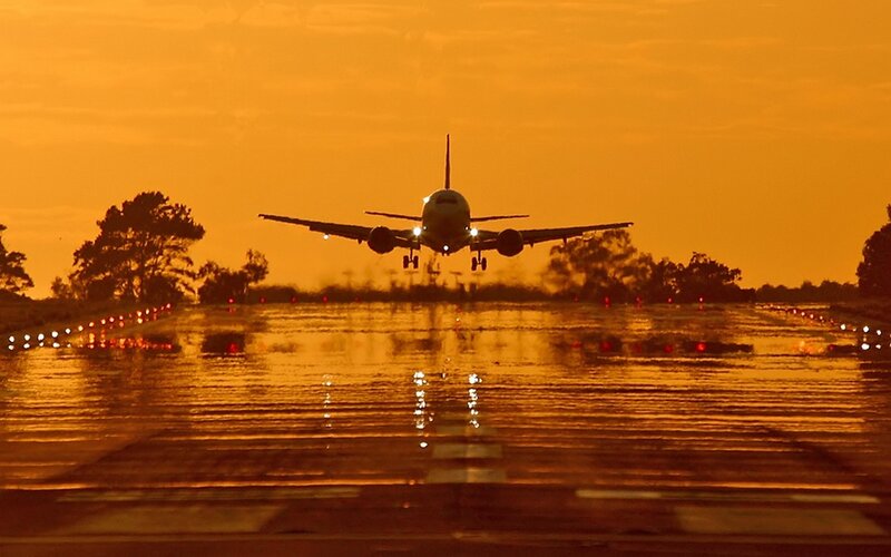 Airplane landing at sunset
