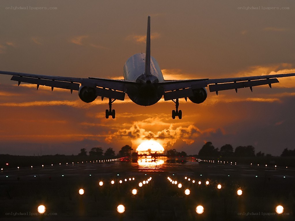 Airplane landing at sunset