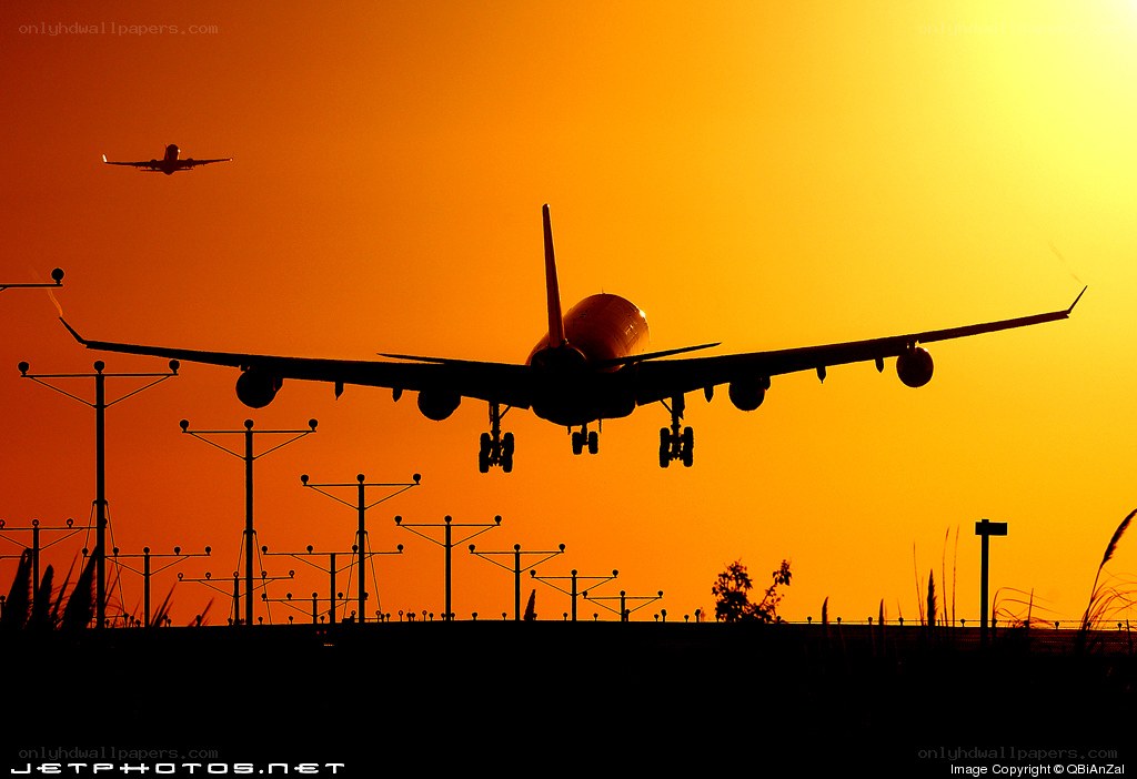 Airplane landing at sunset