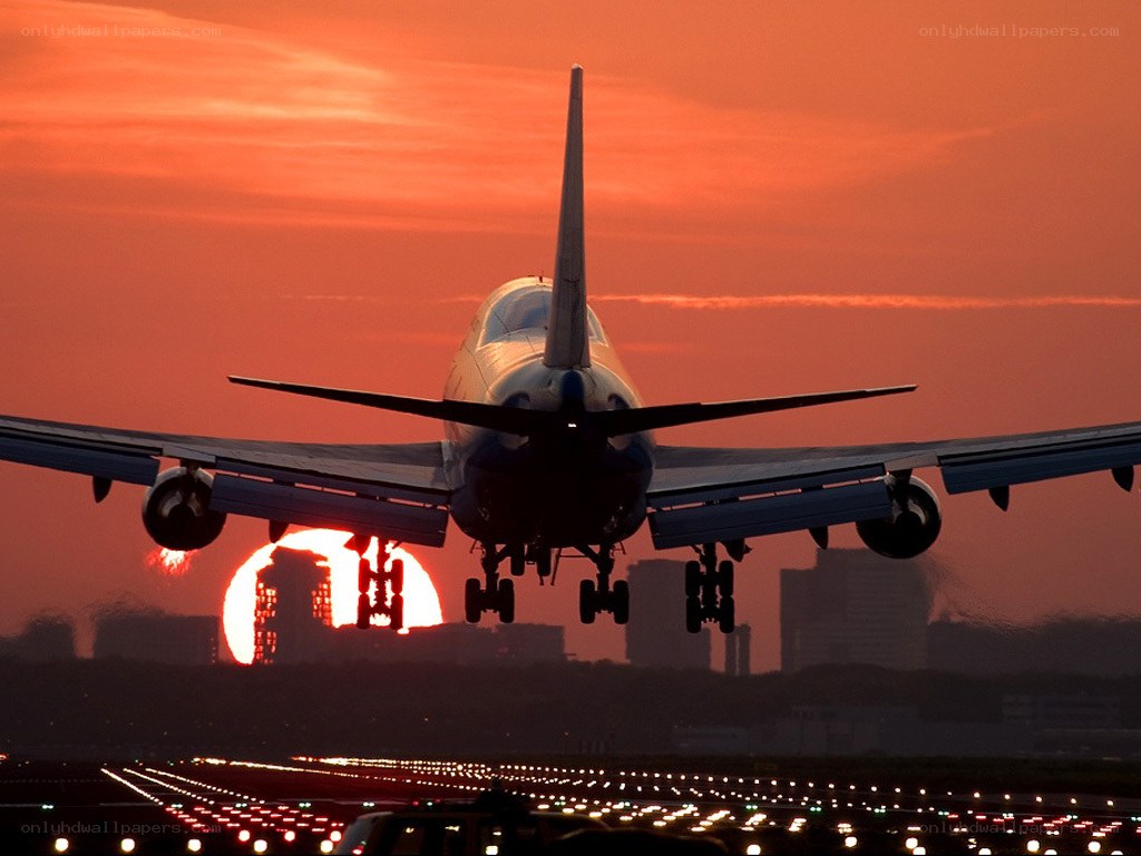 Airplane landing at sunset