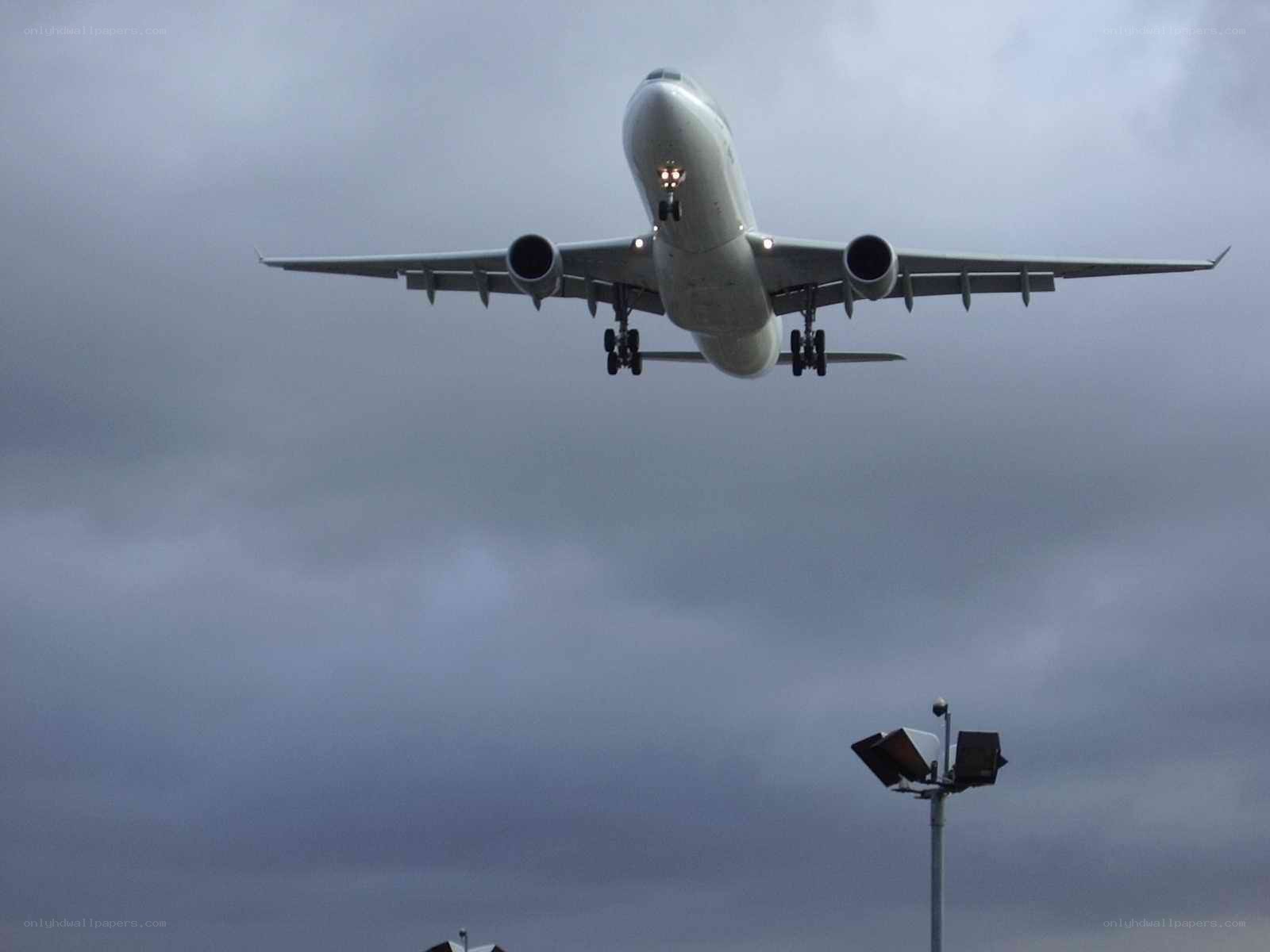 Airplane landing in cloudy sky