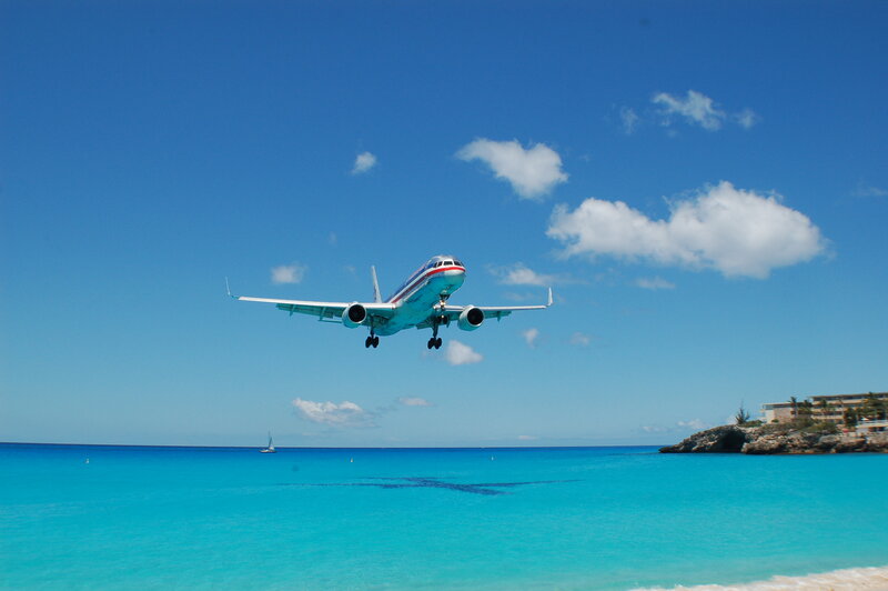 Airplane landing over turquoise water