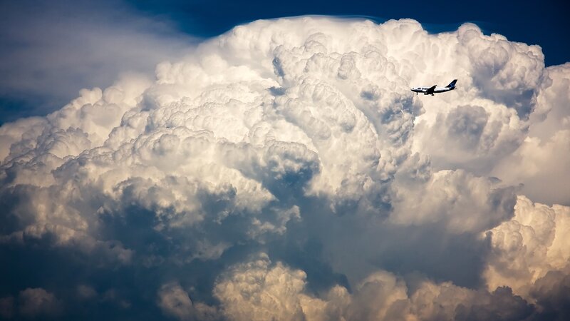 Airplane Near Storm Cloud — White, Dramatic