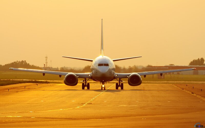 Airplane on runway at sunset