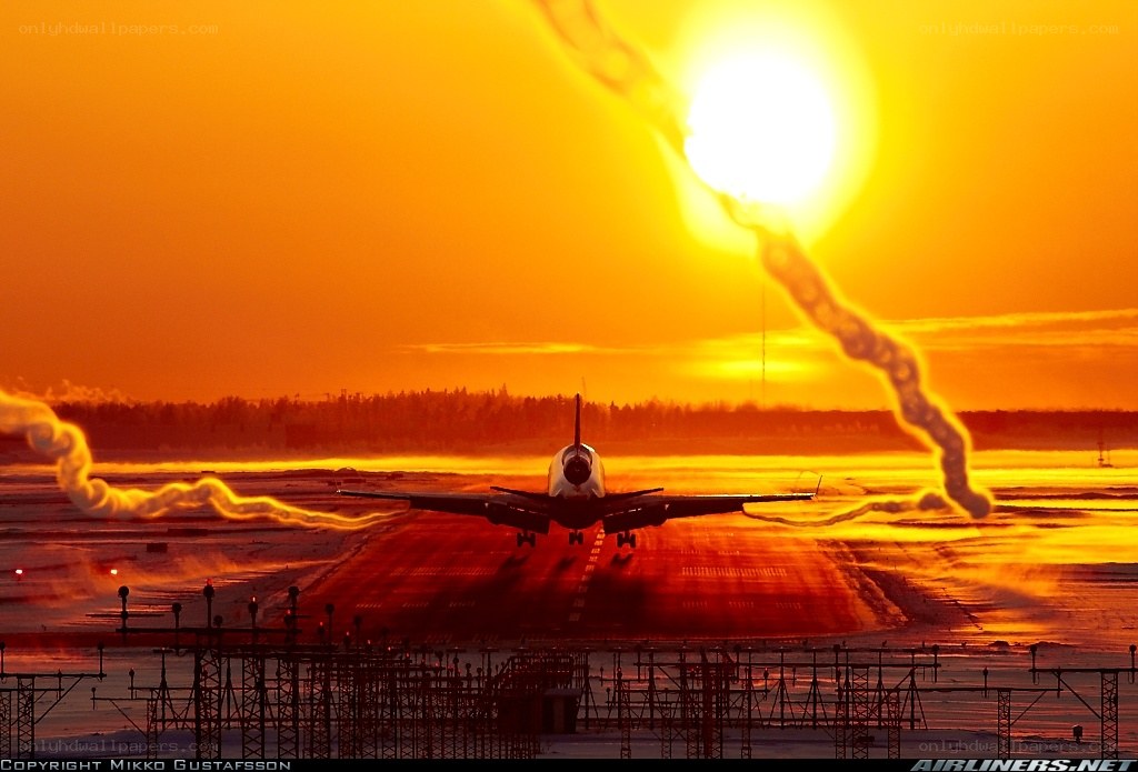 Airplane on runway at sunset
