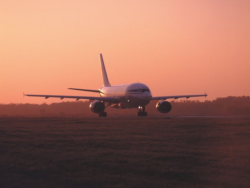 Airplane on runway at sunset