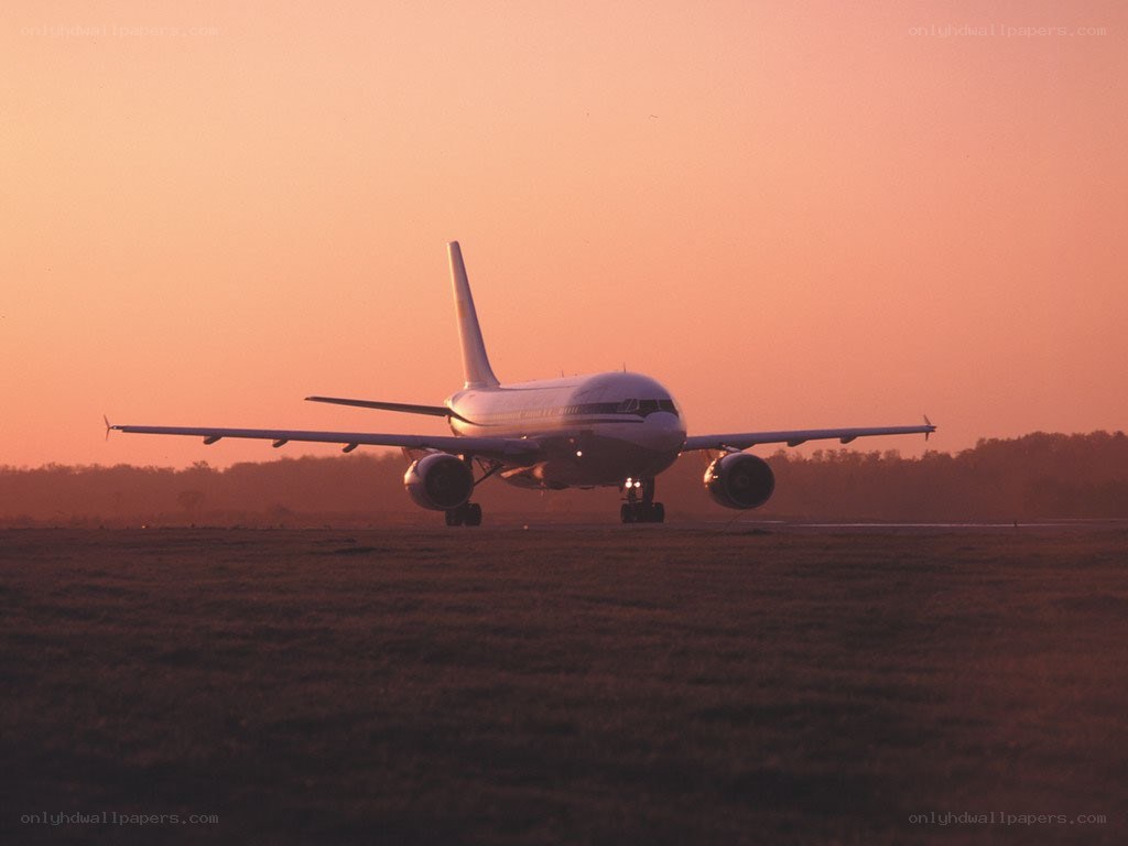 Airplane on runway at sunset