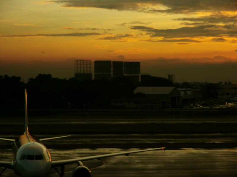 Airplane on Runway — Orange, Dramatic, Sunset, Photograph, Buildings