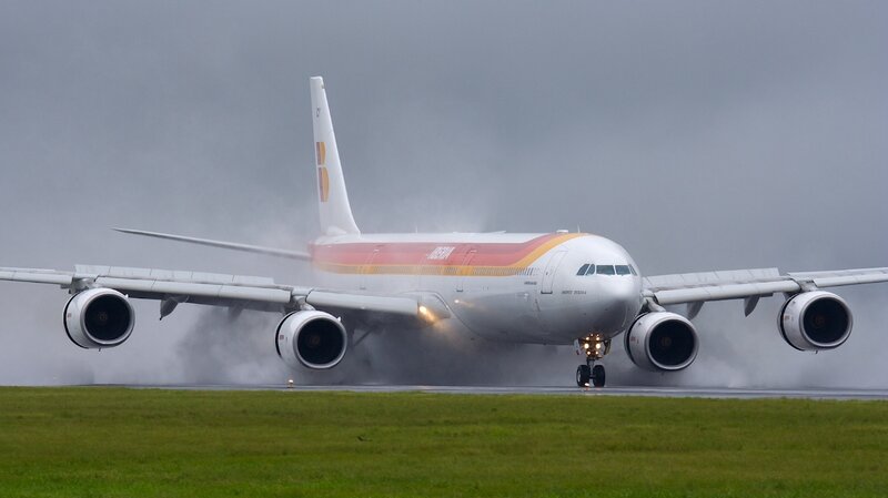 Airplane on Runway — White, Overcast, Photograph