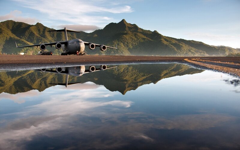 Airplane on runway with mountain reflection