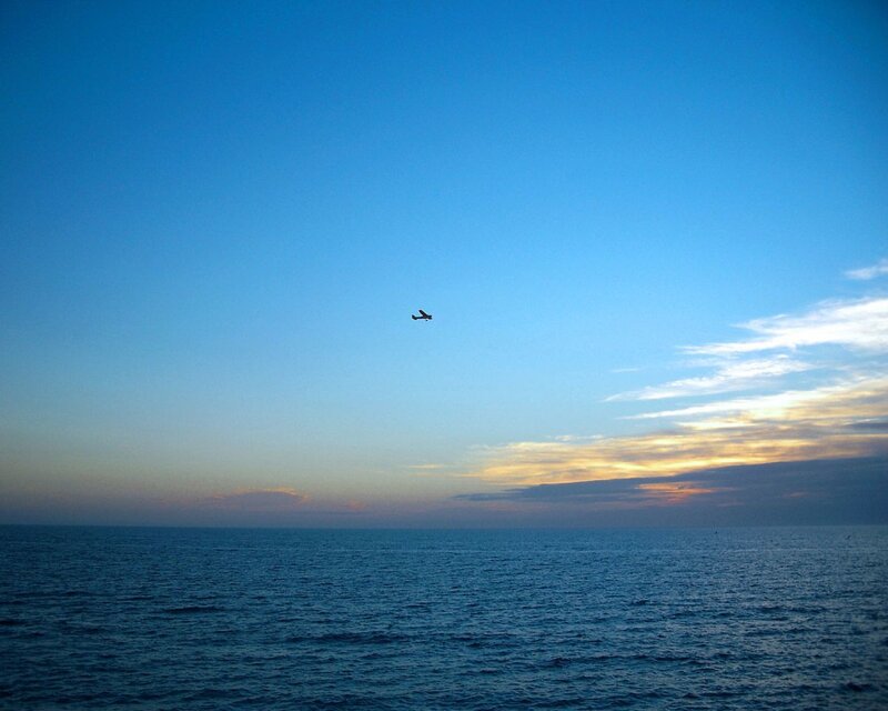 Airplane over the ocean at dusk