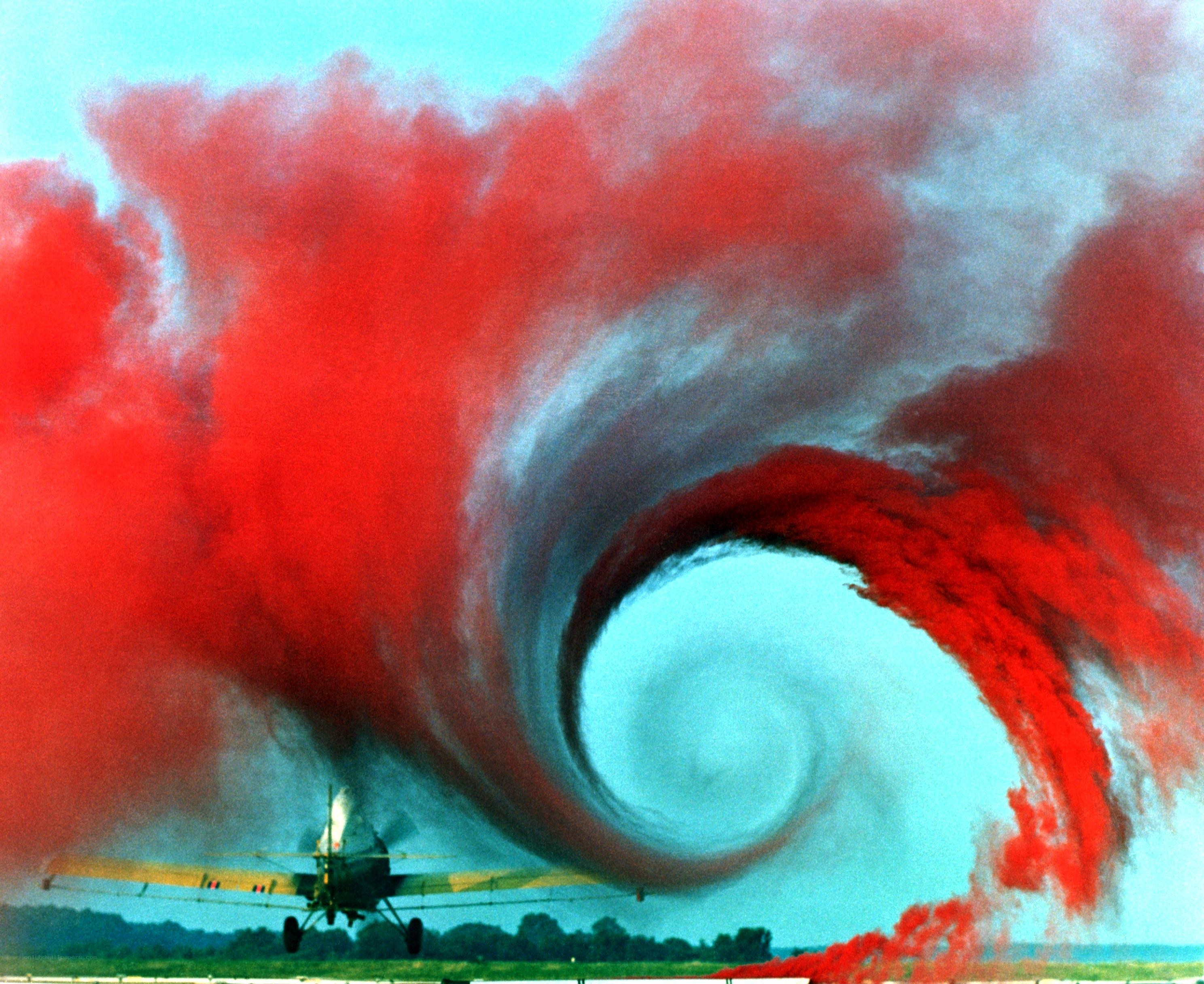 Airplane releasing red smoke
