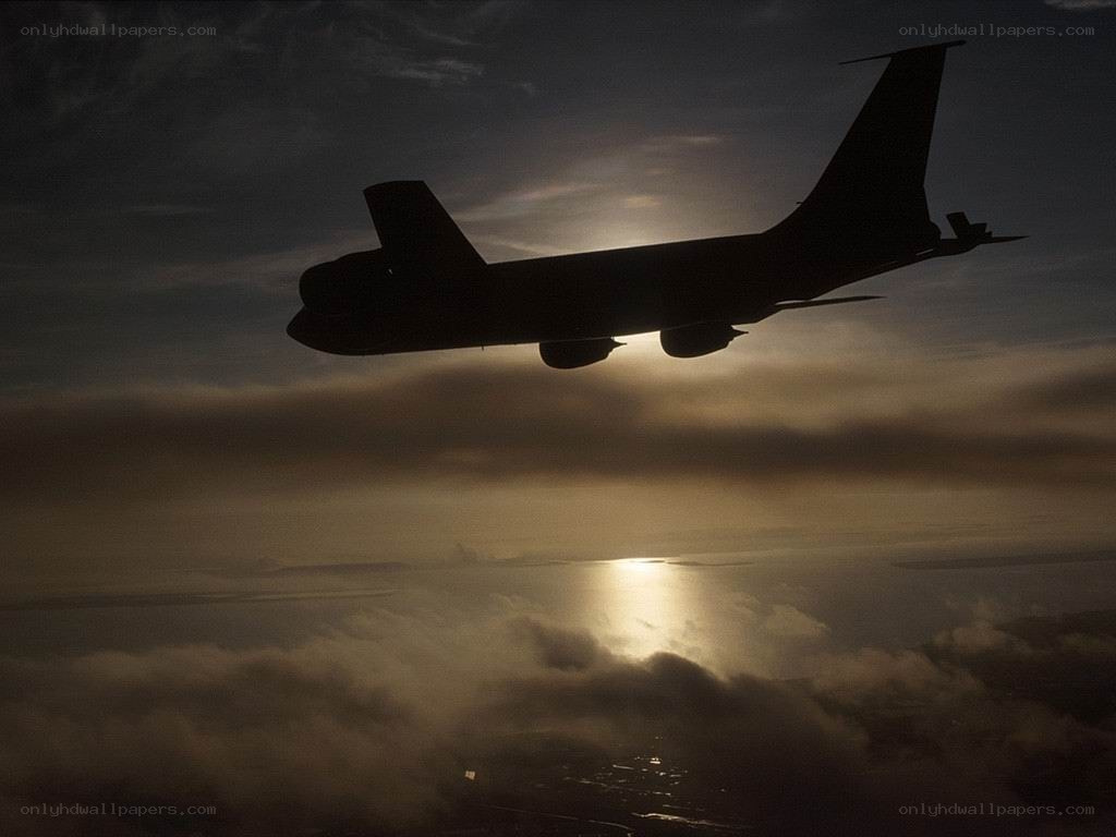 Airplane silhouetted against sunset