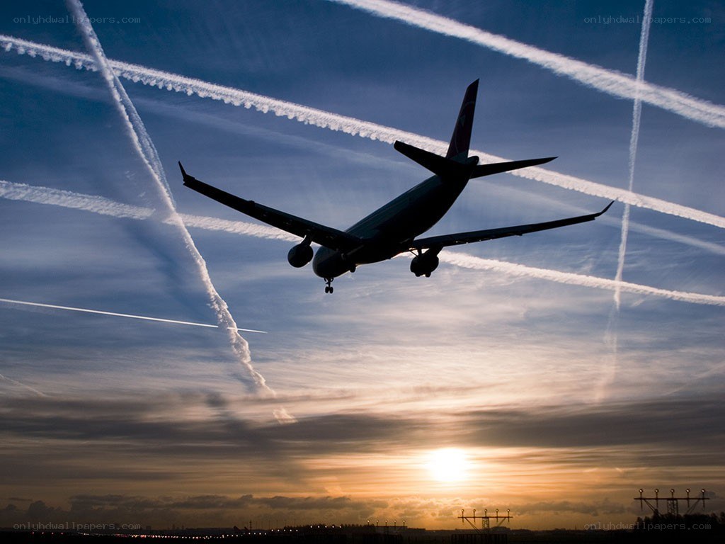 Airplane silhouetted against sunset