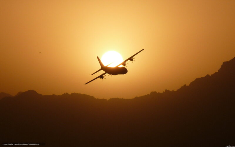 Airplane silhouetted against sunset