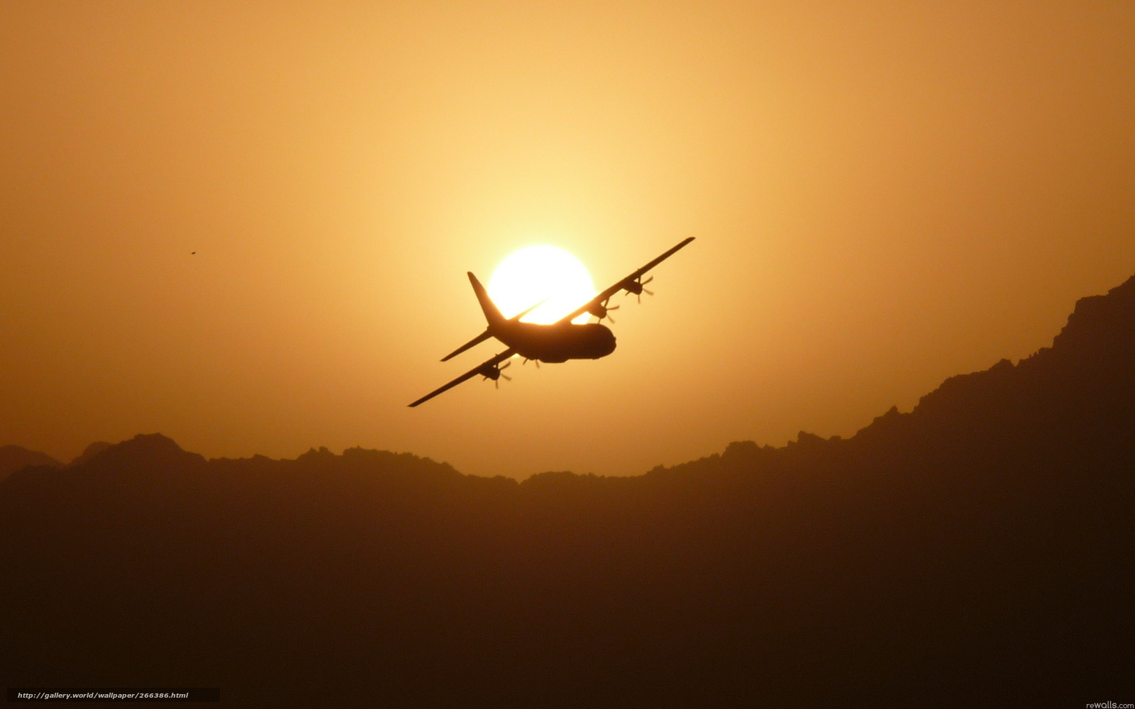 Airplane silhouetted against sunset