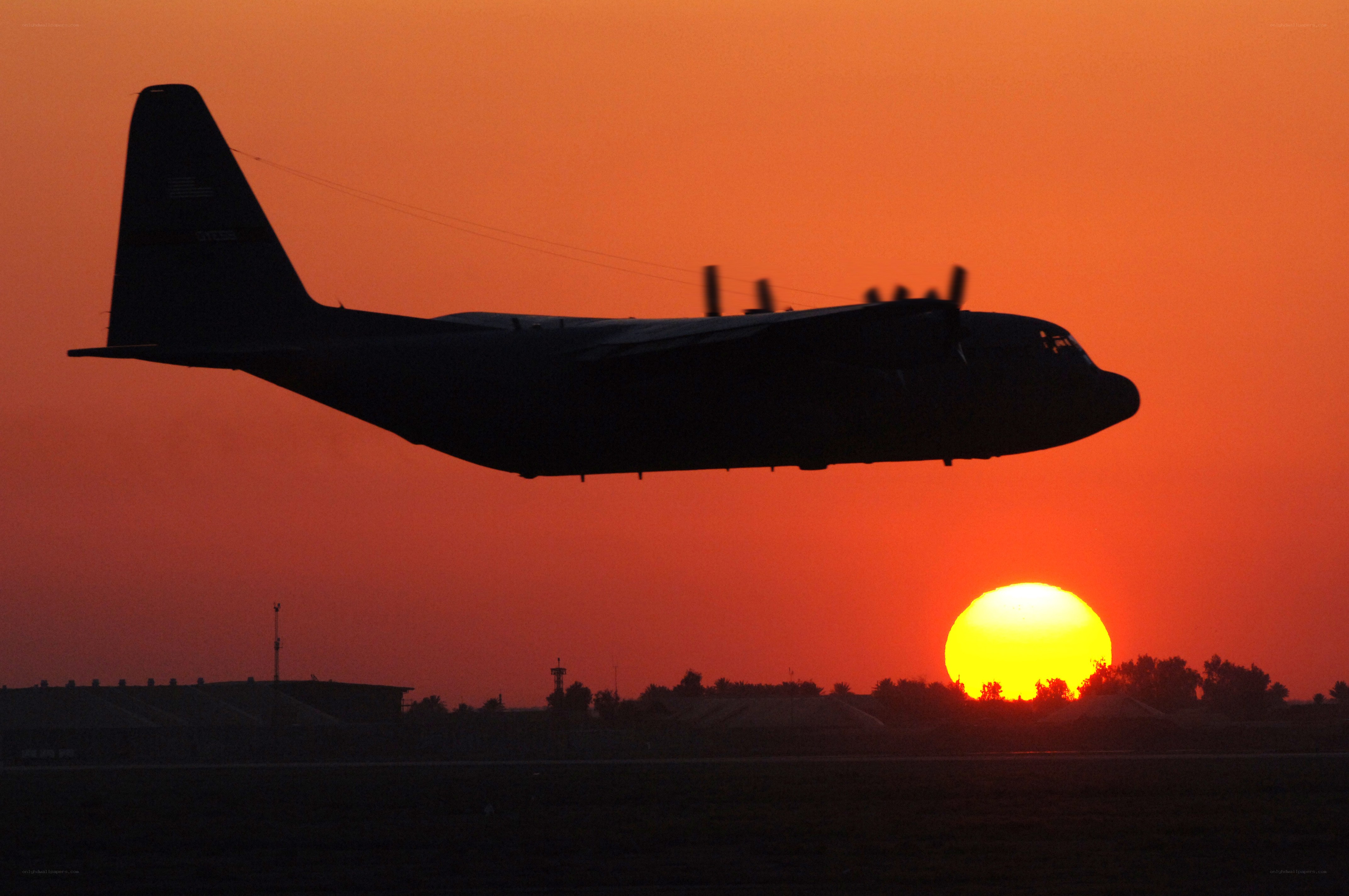 Airplane silhouetted at sunset