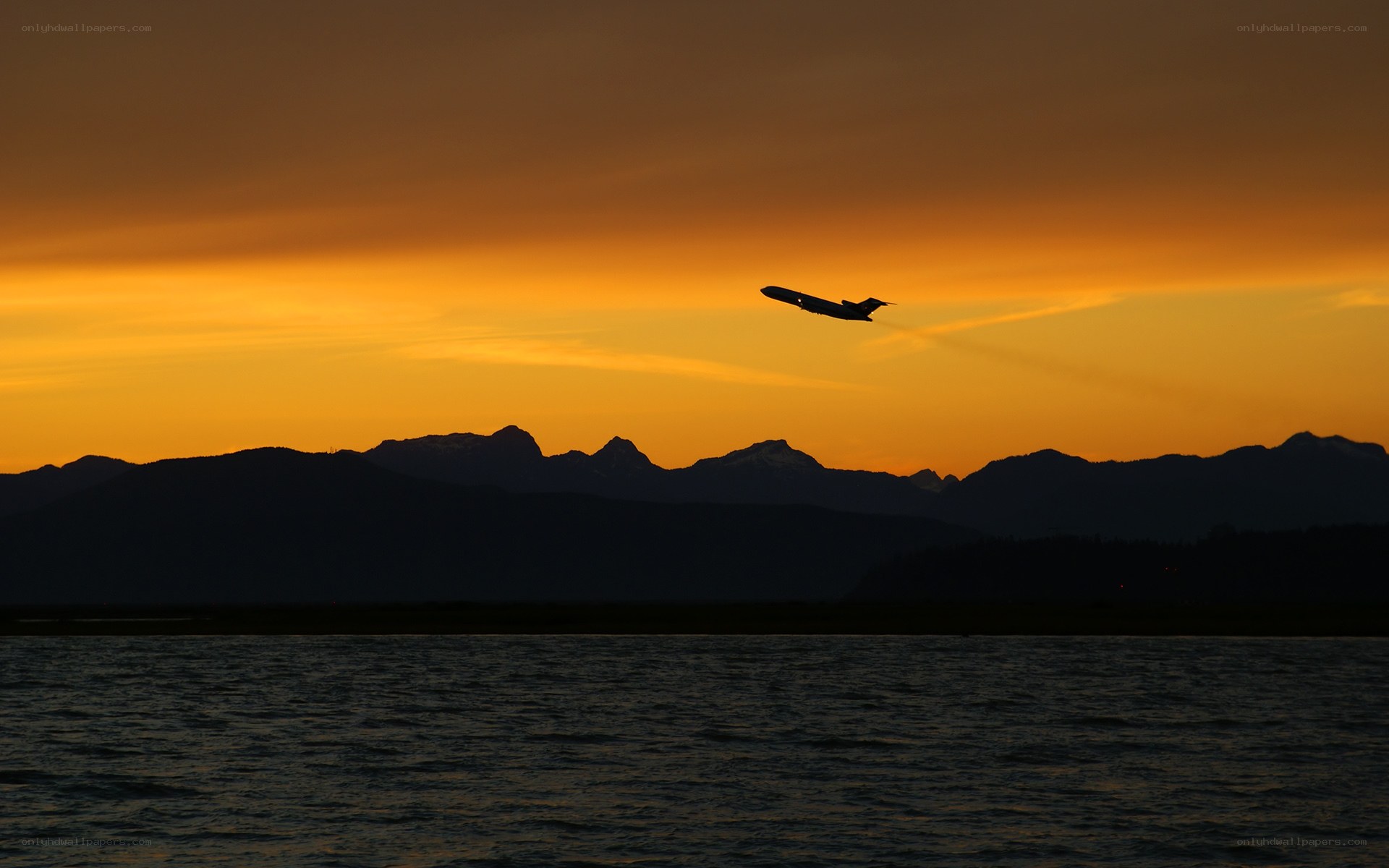 Airplane silhouetted at sunset