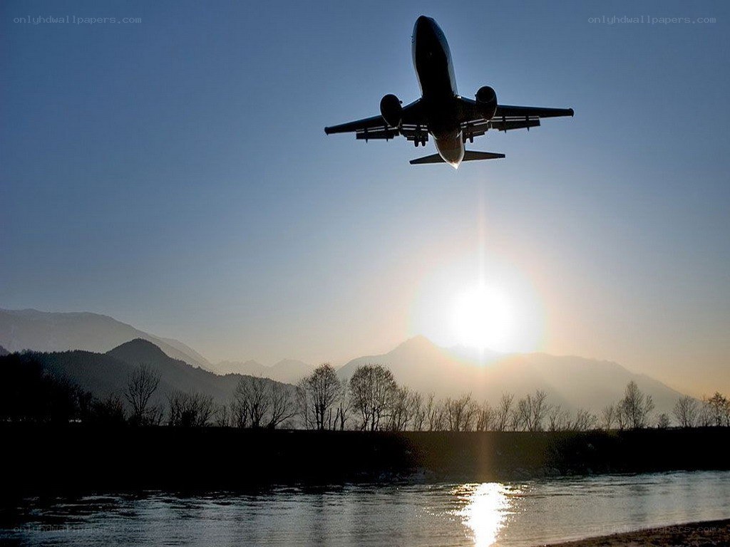 Airplane taking off at sunset