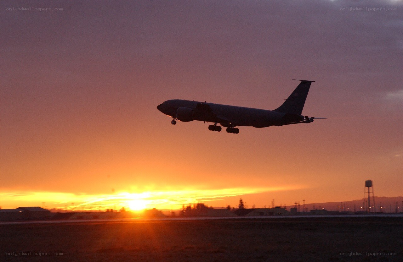 Airplane taking off at sunset
