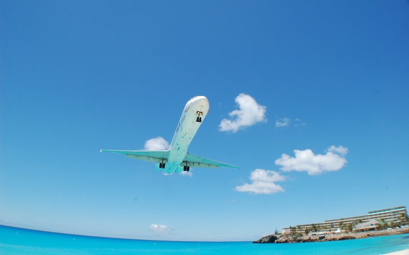 Airplane taking off over beach