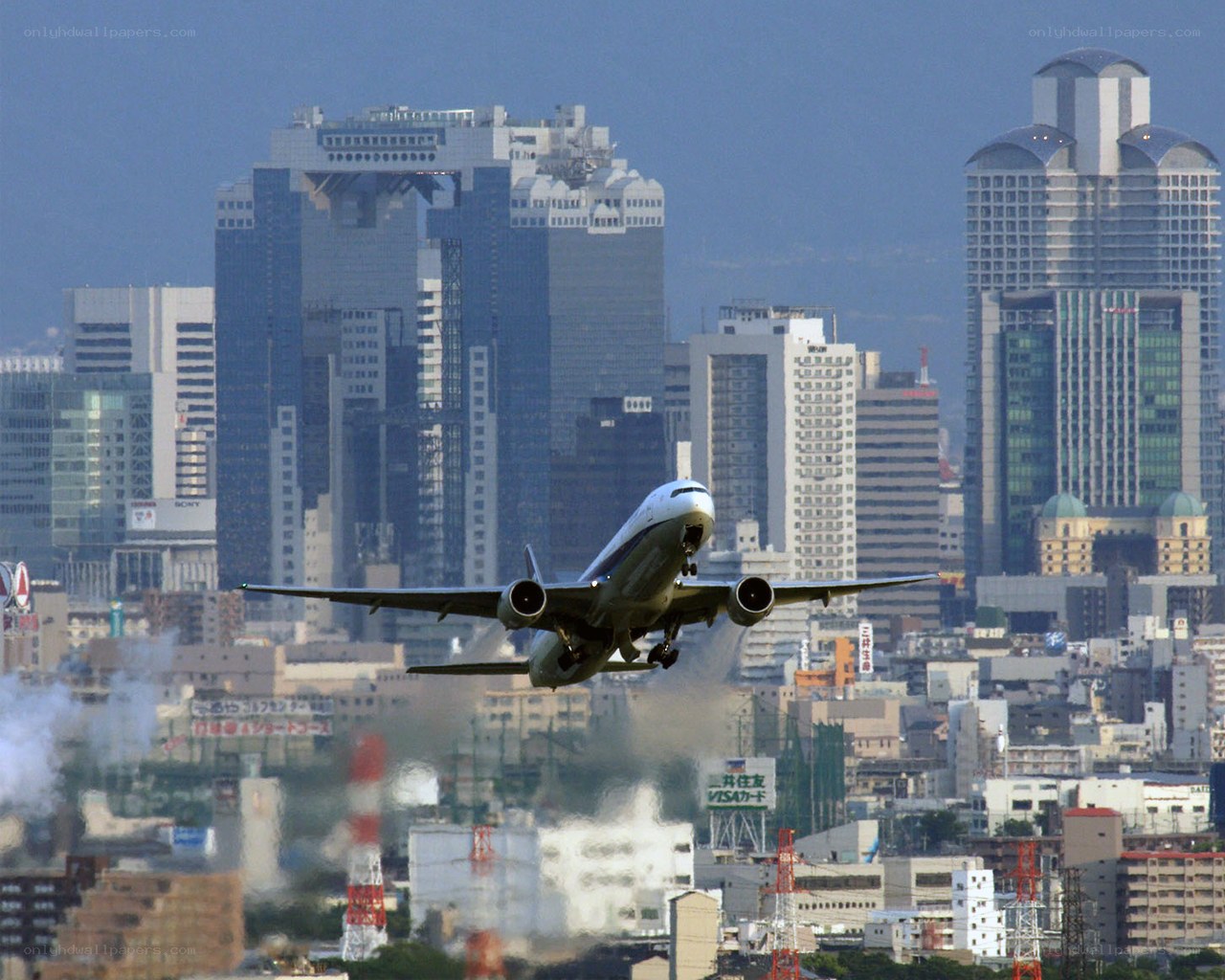 Airplane taking off over city