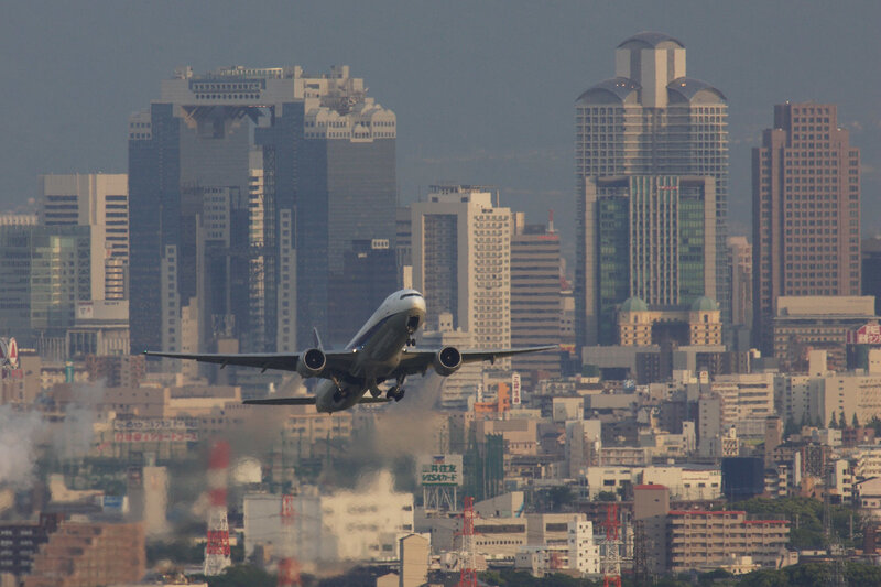 Airplane taking off over city