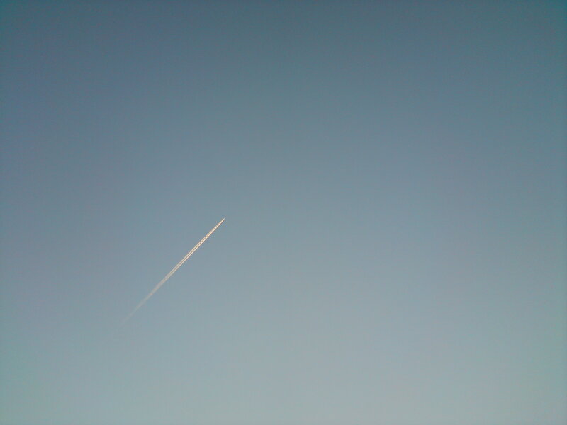 Airplane trail in blue sky