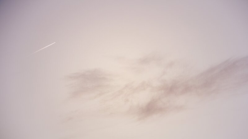 airplane trail in cloudy sky
