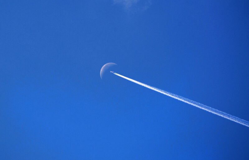 Airplane trail near moon