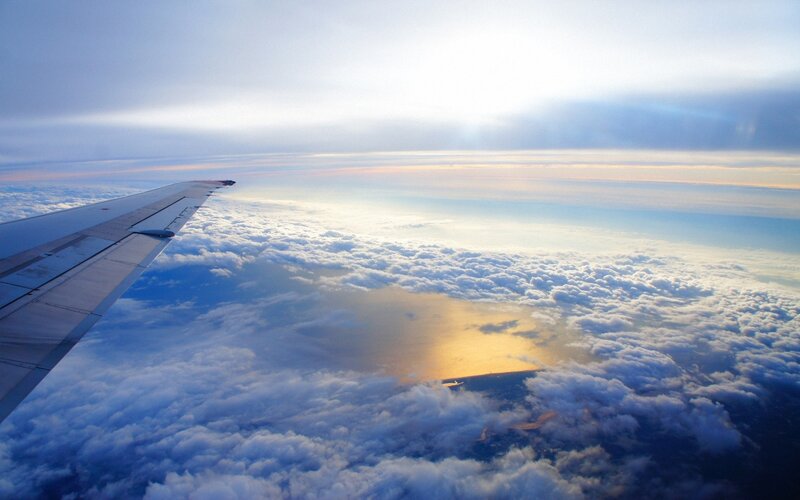 airplane wing above clouds
