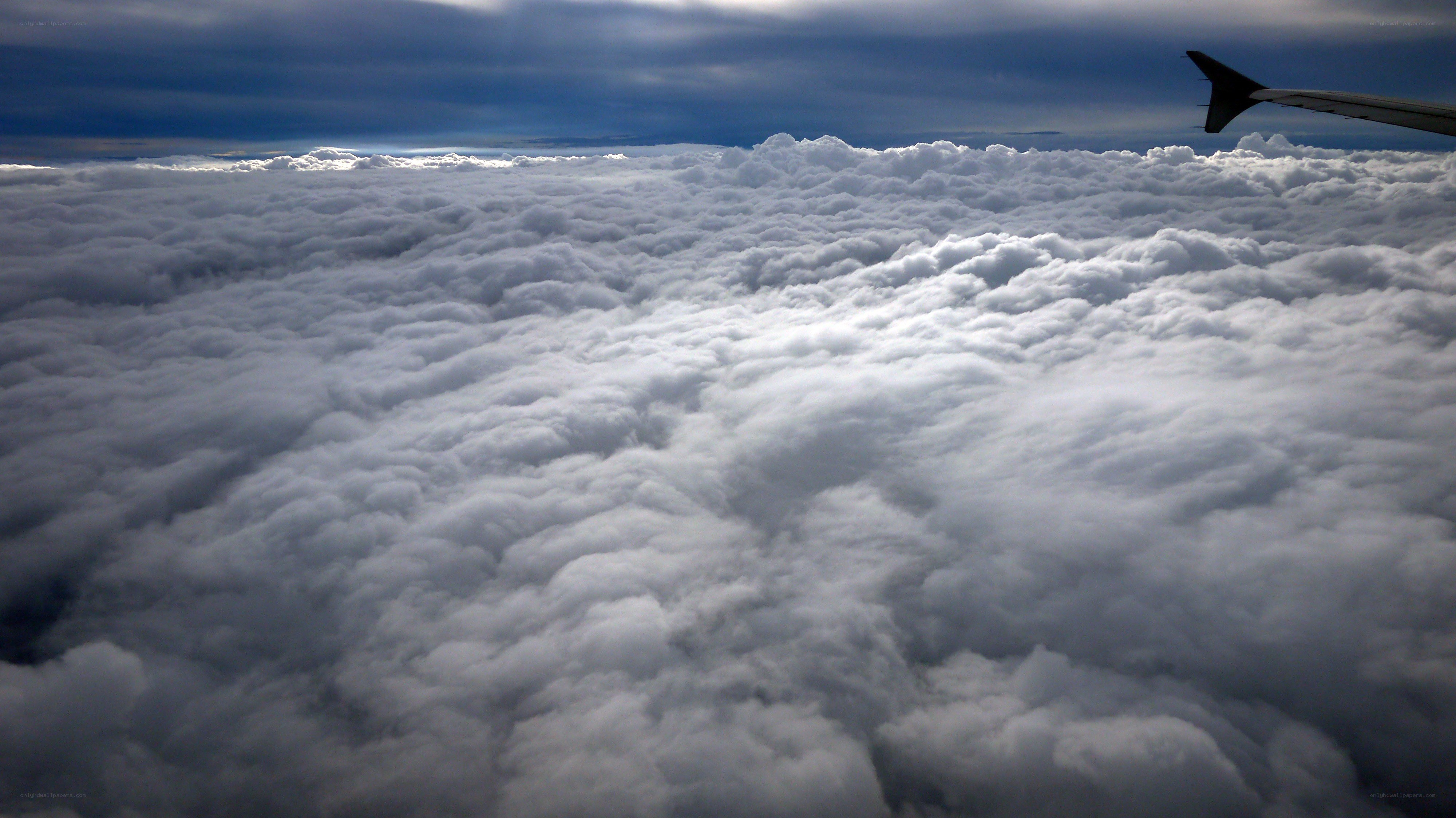 airplane wing above clouds