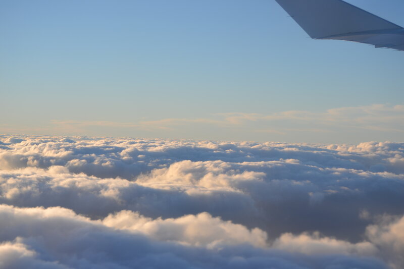 Airplane Wing Above Clouds — Blue, Serene, Sunrise